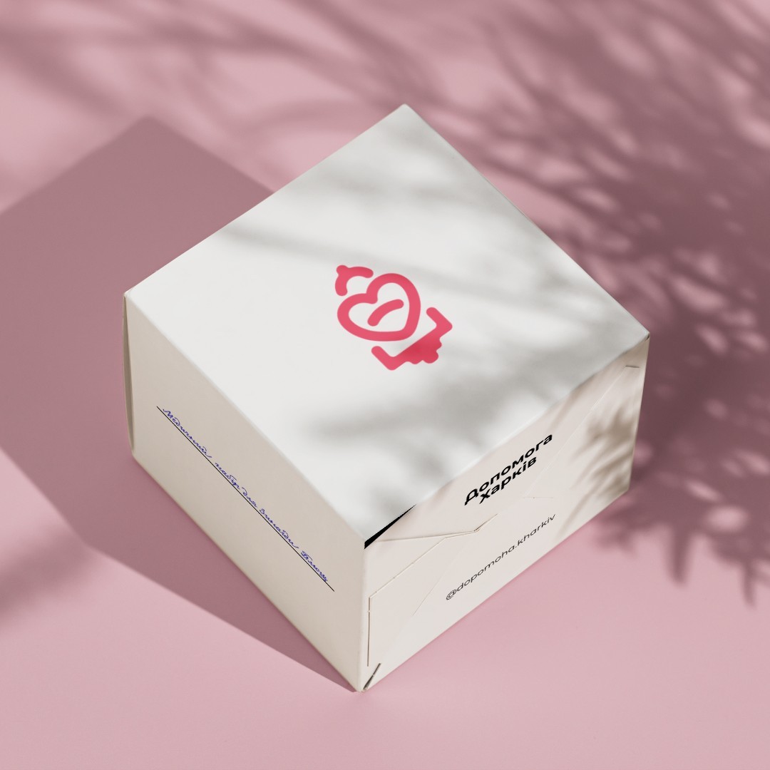 A white box on a pink background with the brand logo on the front surface.