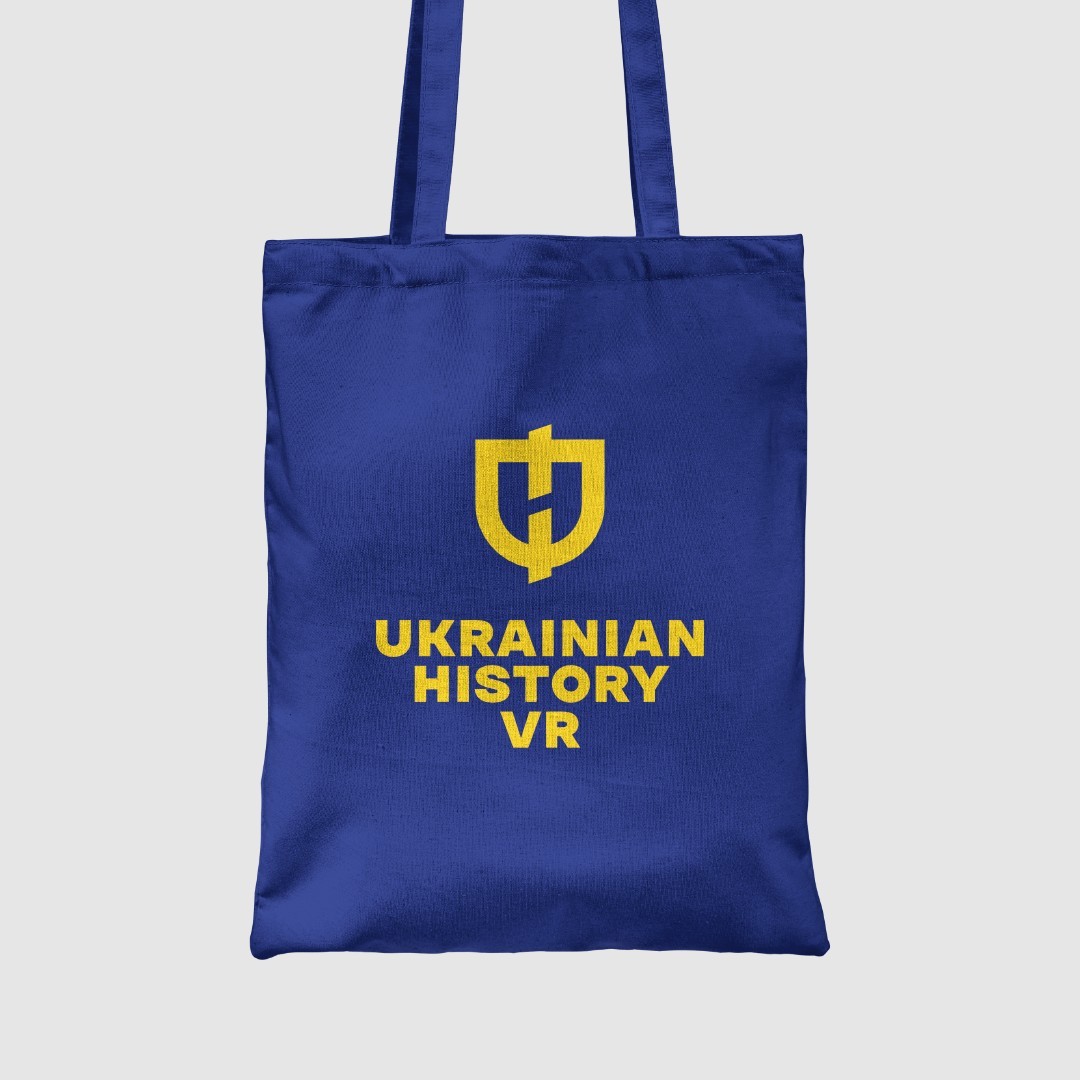 A blue tote bag with the logo in yellow.